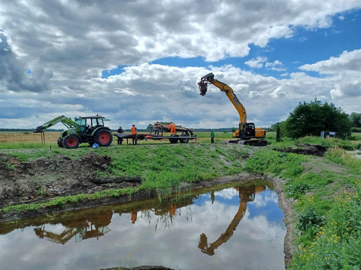 Graafmachines en werklui op een dijk