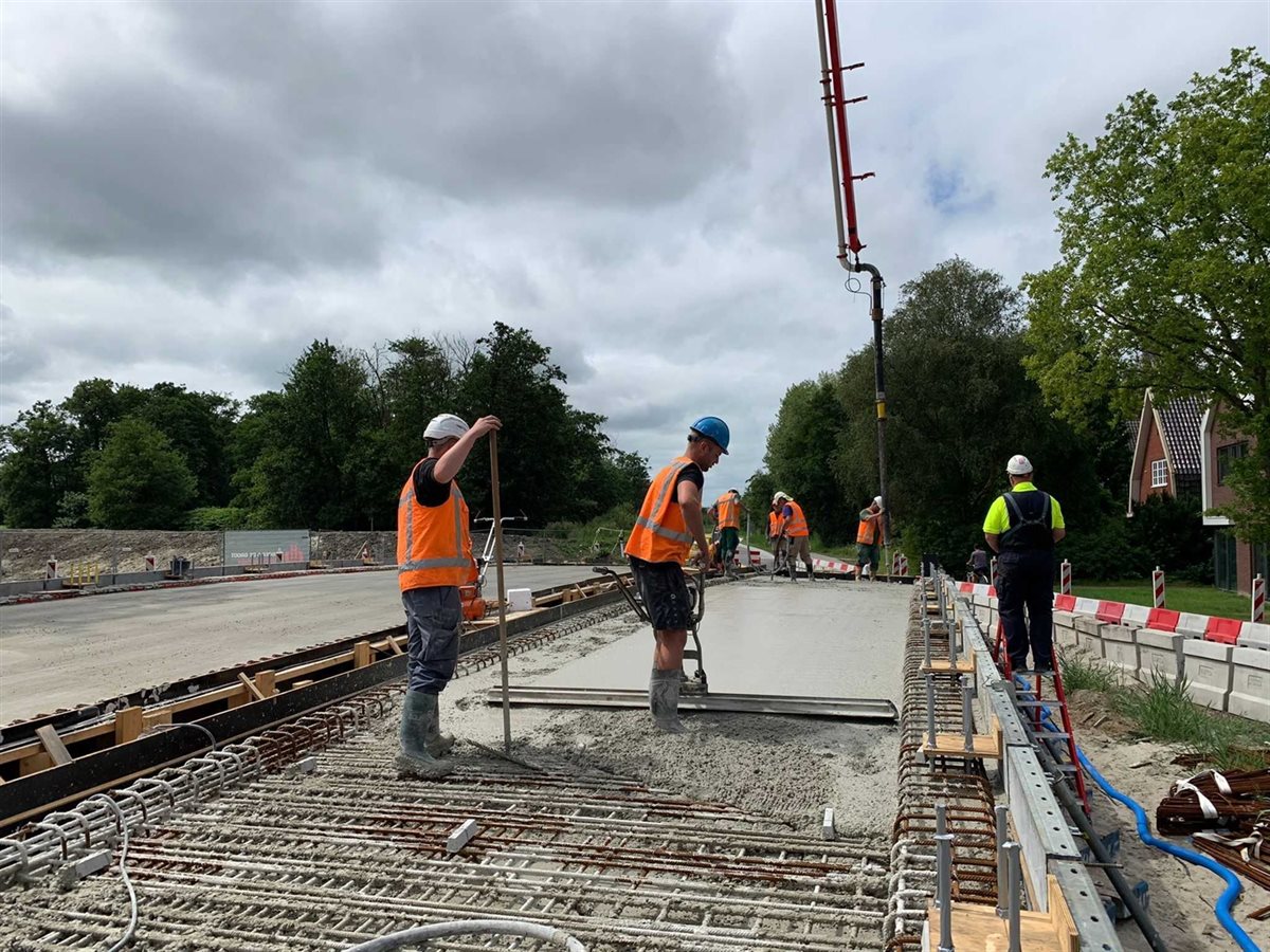 Werklui op het brugdek bezig met het storten van beton