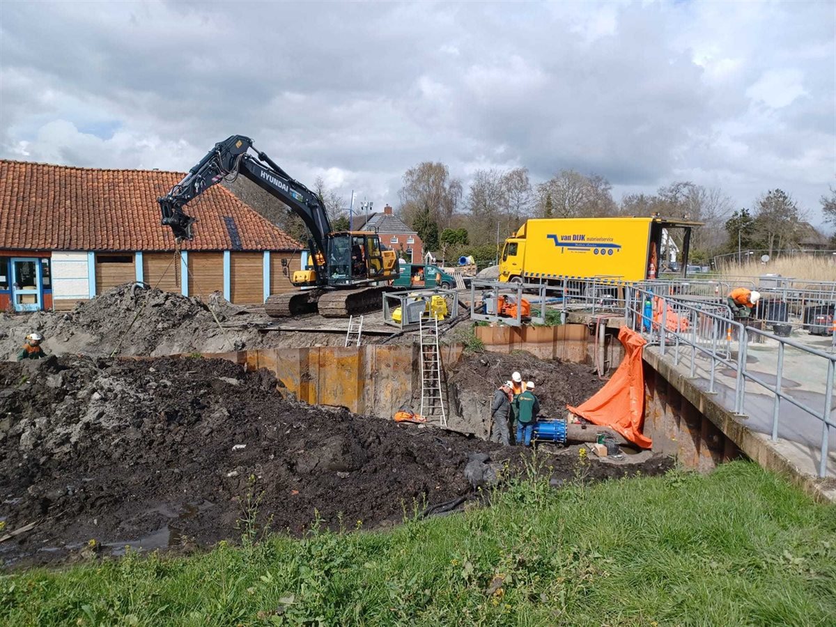 Bouwplaats met een graafmachine, werklui en een vrachtwagen